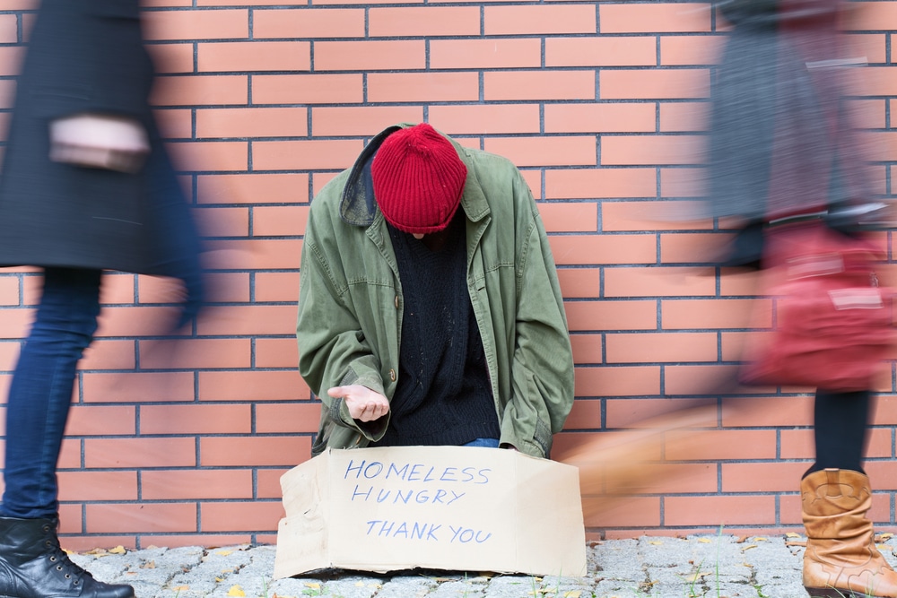 shot-of-beggar-on-street-with-sign-that-says-homeless-hungry-thank-you
