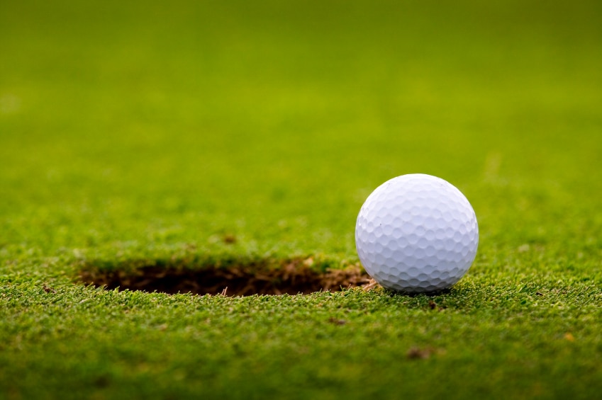 golf-ball-close-to-hole-on-grassy-field