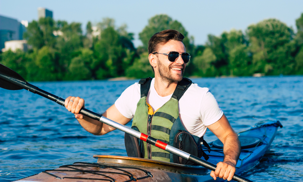 handsome-man-smiling-and-paddling-canoe