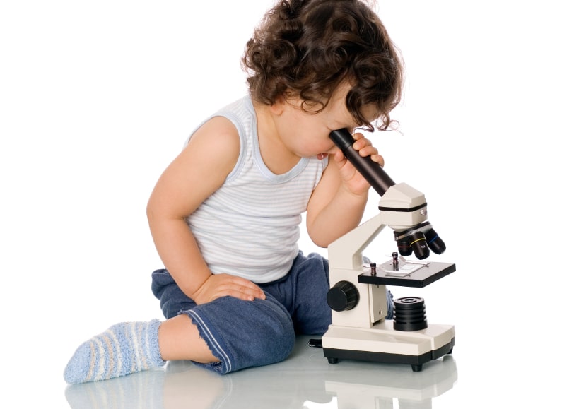 child looking at a microscope