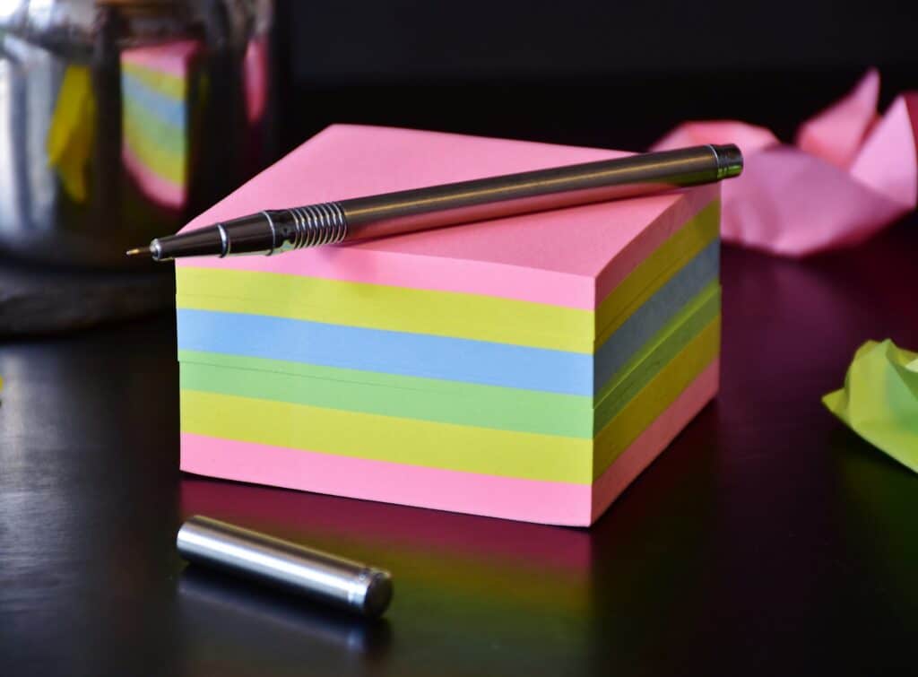 stack-of-multicolored-sticky-notes-with-uncapped-pen-on-top