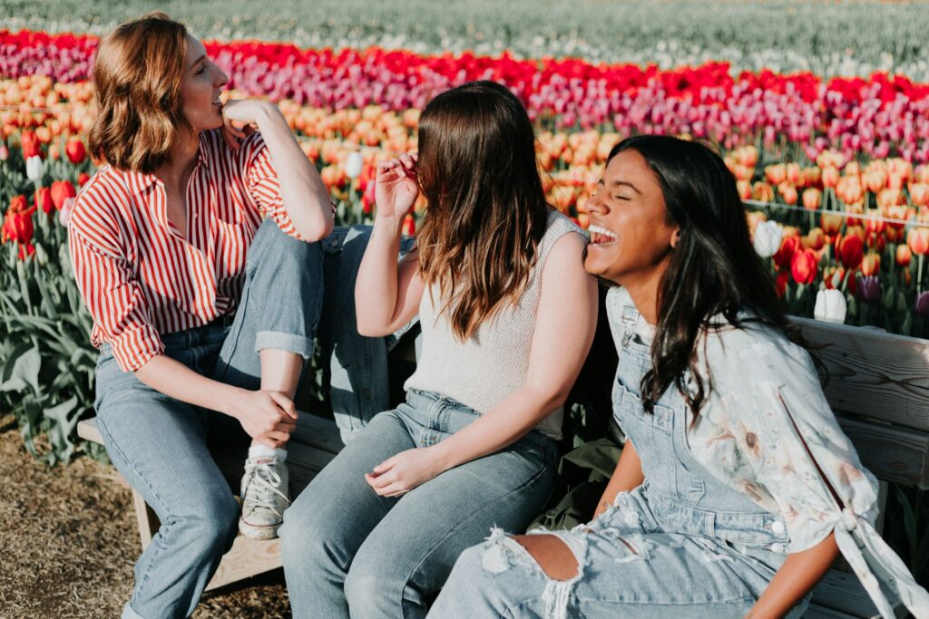 group of friends laughing together in a field of tulips