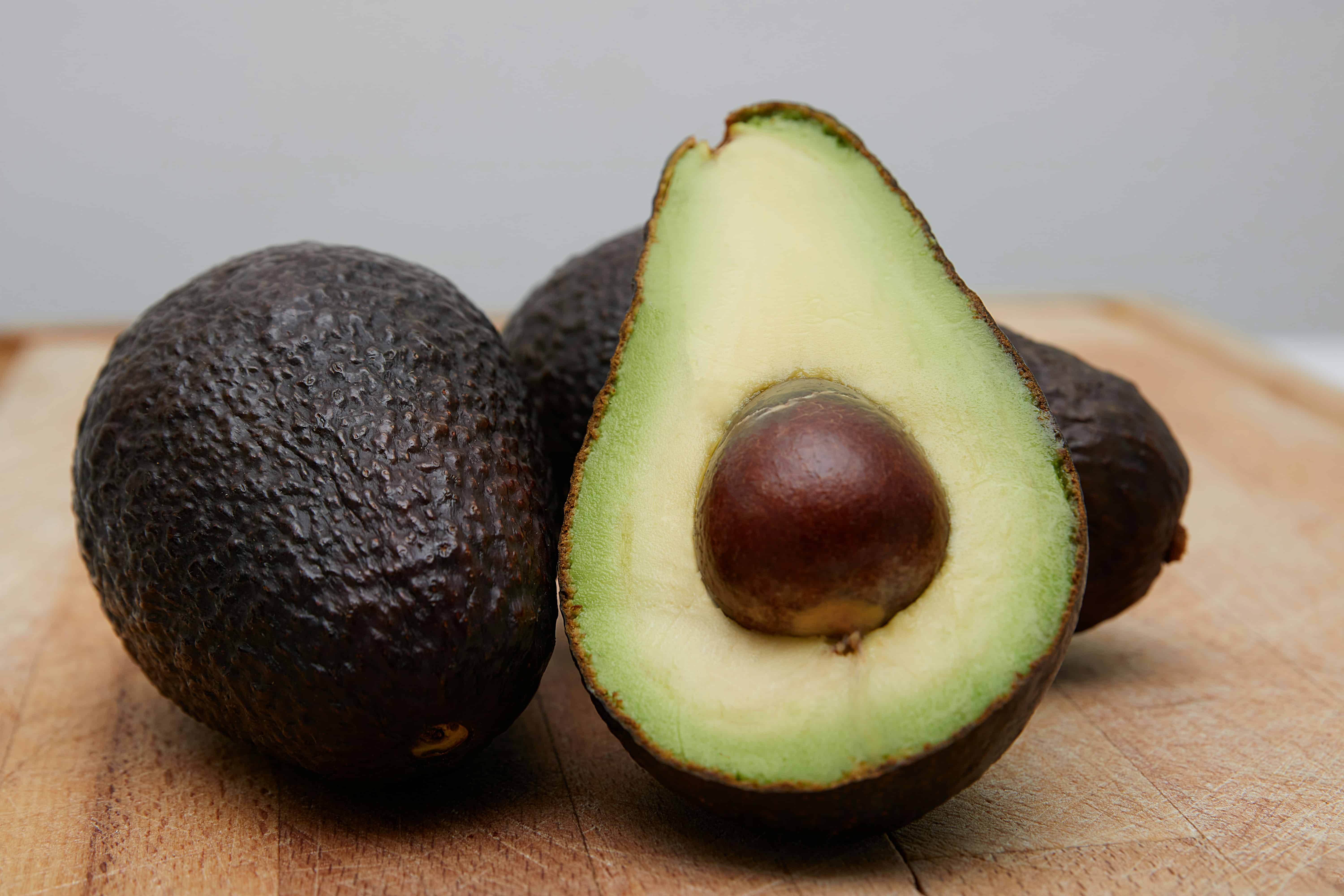 A sliced avocado on a wooden table