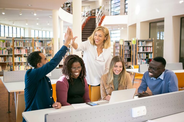 Teacher high fiving students in library