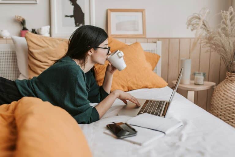 Girl lying on bed watching laptop