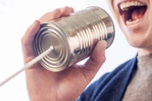 man yelling into tin can telephone