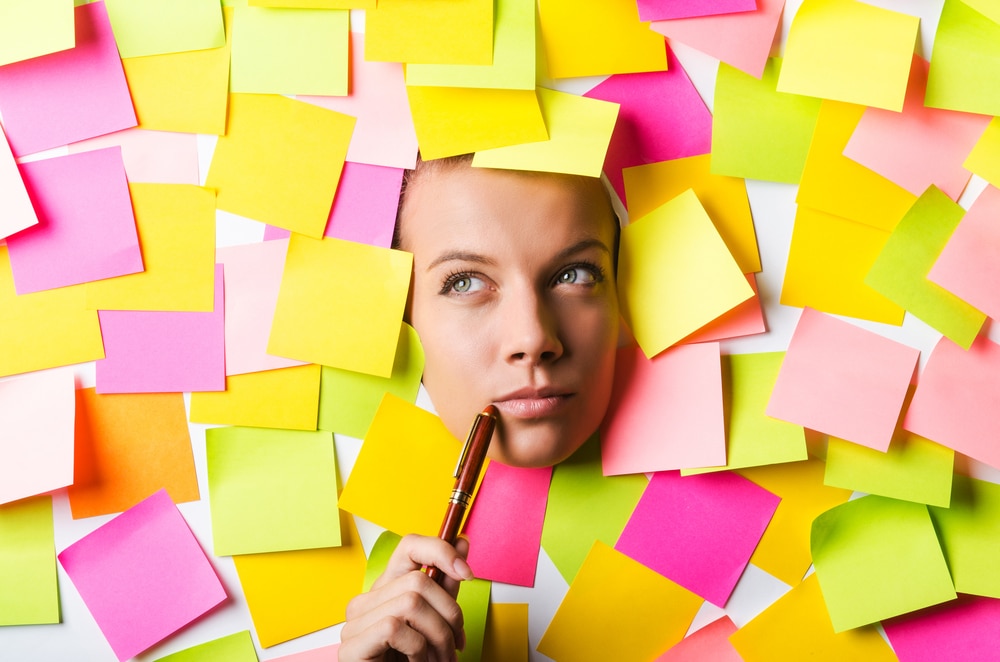 woman's face poking out of a board with sticky notes