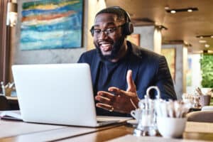 guy wearing headphones while video chatting on his laptop