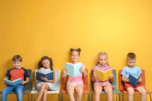 five children reading on a bench