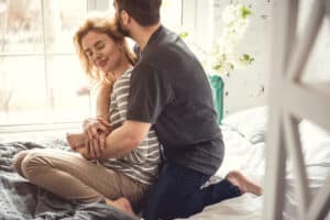 man hugging a woman from behind while on the floor