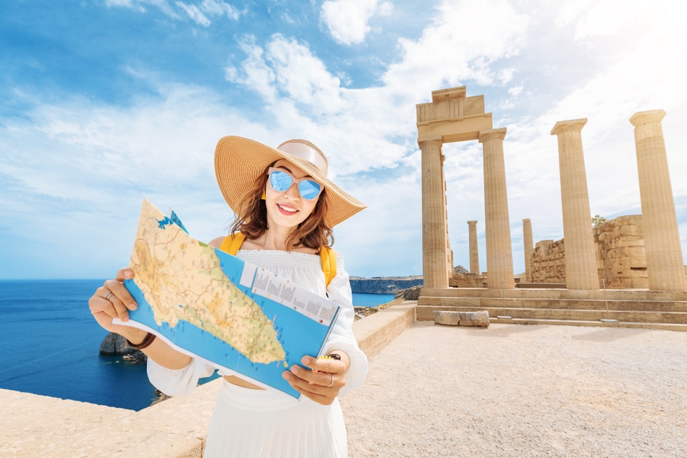 young brown haired woman traveling and holding a map