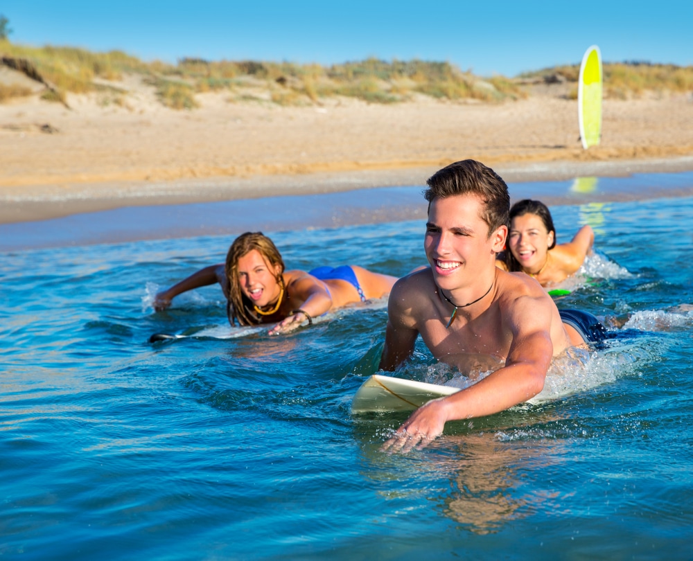 three teenagers surfing in the ocean