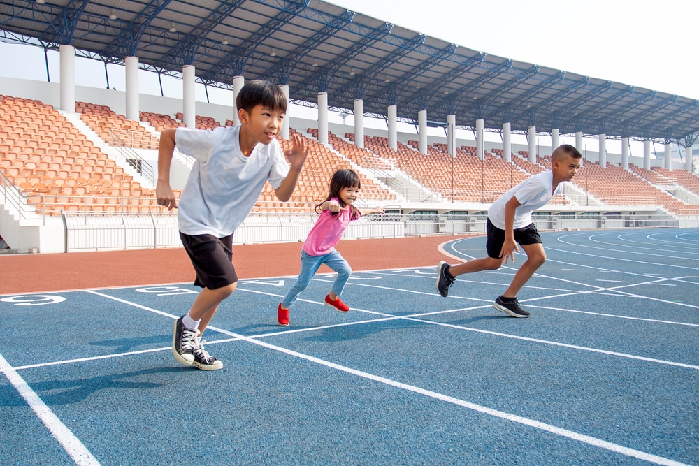 three young kids sprinting on a track