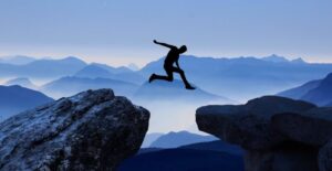 a person taking a leap between two rocks