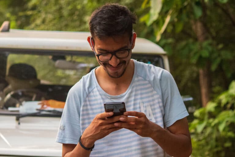 Man smiling at the phone in his hands