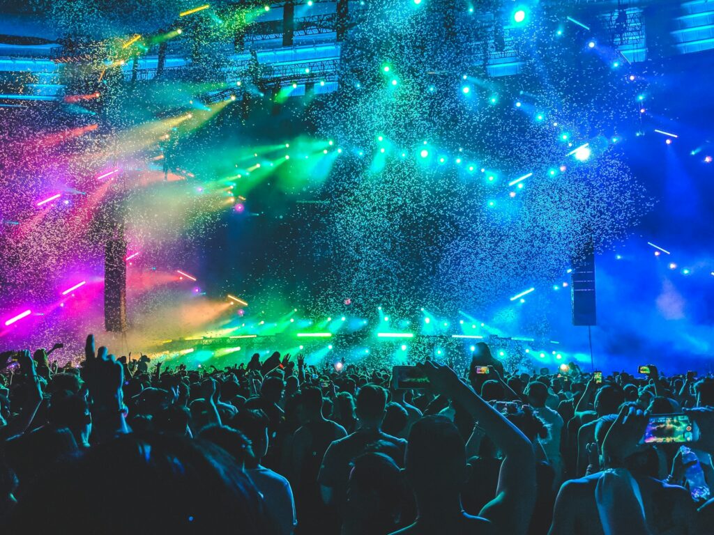 crowd gathered at a concert, colorful lights and confetti