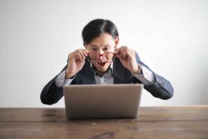 man looking surprised at laptop