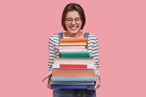 woman happily holding a stack of books