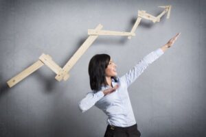 businesswoman holding arms diagonally upwards