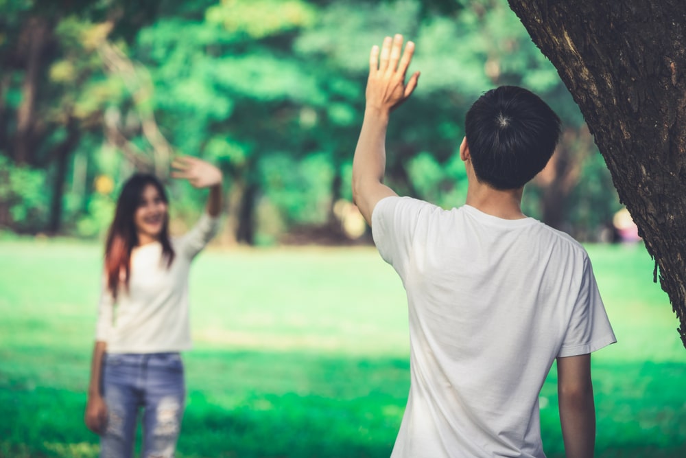 man and woman saying hello at the park