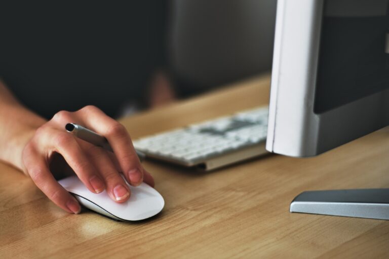 hand-holding-computer-mouse-next-to-keyboard