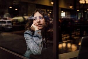 woman-thoughtfully-looking-out-of-a-window