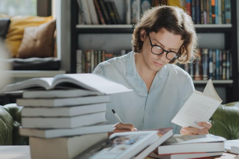 Person studying next to stack of books