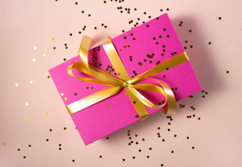 https://www.fluentu.com/blog/wp-content/uploads/2023/10/hot-pink-gift-box-with-gold-ribbon-and-glitter-1024x708.jpg