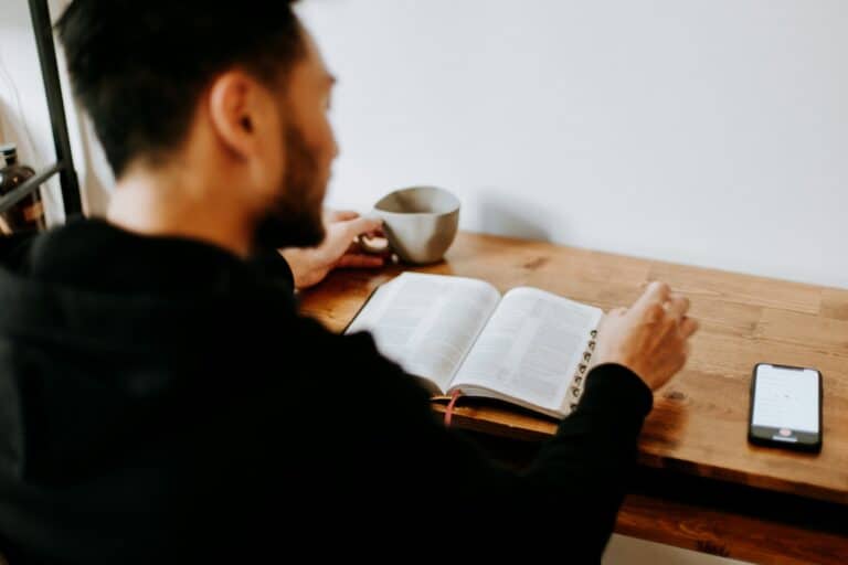 man in black sweater studying at desk