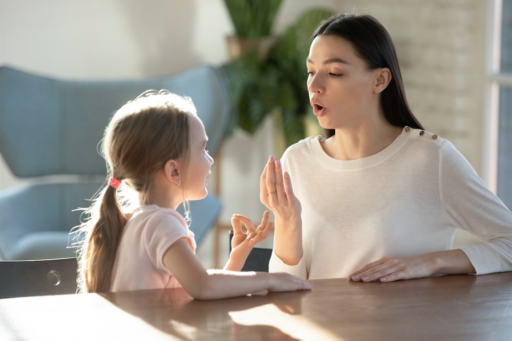 woman teaching girl to speak