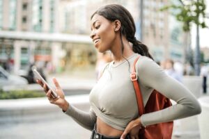 happy woman out and about using her phone