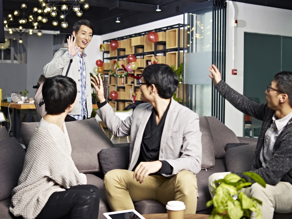 chinese office worker saying goodbye to colleagues