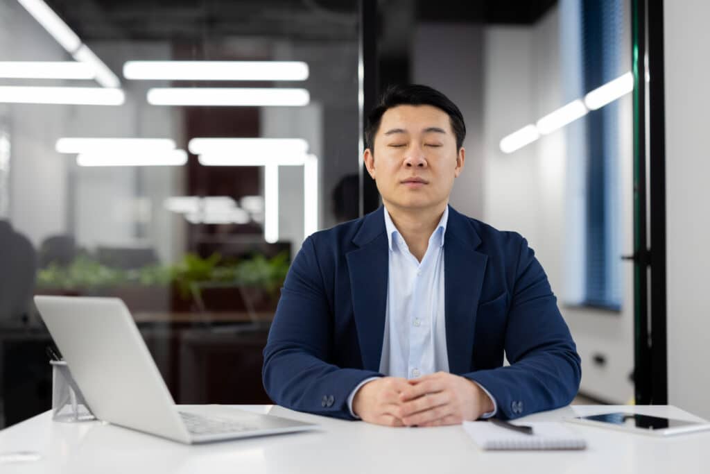 man-breathing-with-eyes-closed-in-office