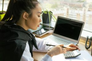 woman-using-calculator-at-desk