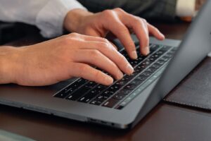 hands typing on a laptop