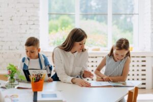 one teacher between two students looking at a book