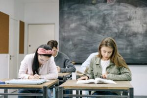 students-sitting-in-a-classroom-writing