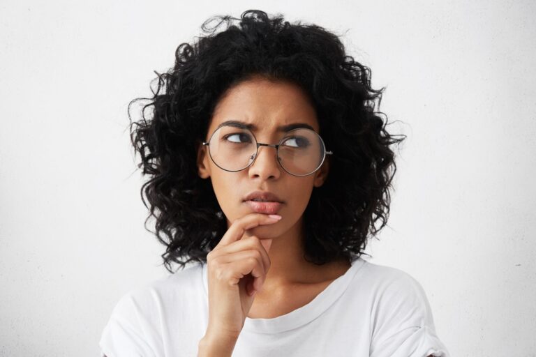 confused woman with curly hair and glasses