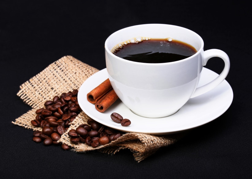 cup of coffee with coffee beans in the background