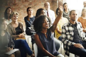 adults in a class raising hands