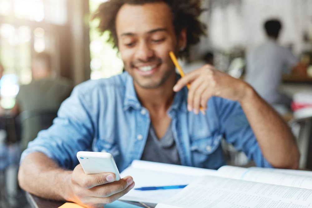 man-using-phone-and-smiling