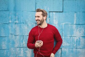 man listening with headphones on phone