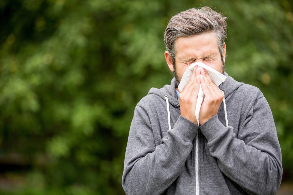 man-sneezing-into-tissue