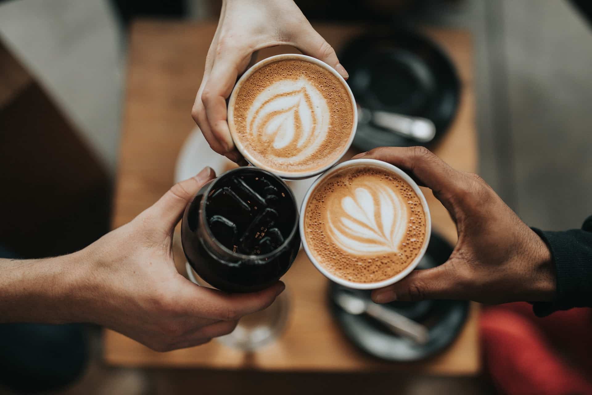 People holding their coffee drinks