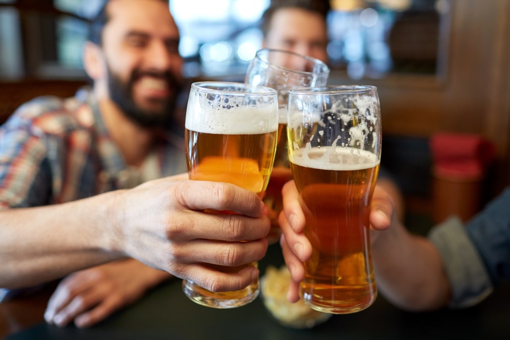 friends clinking glasses at a bar