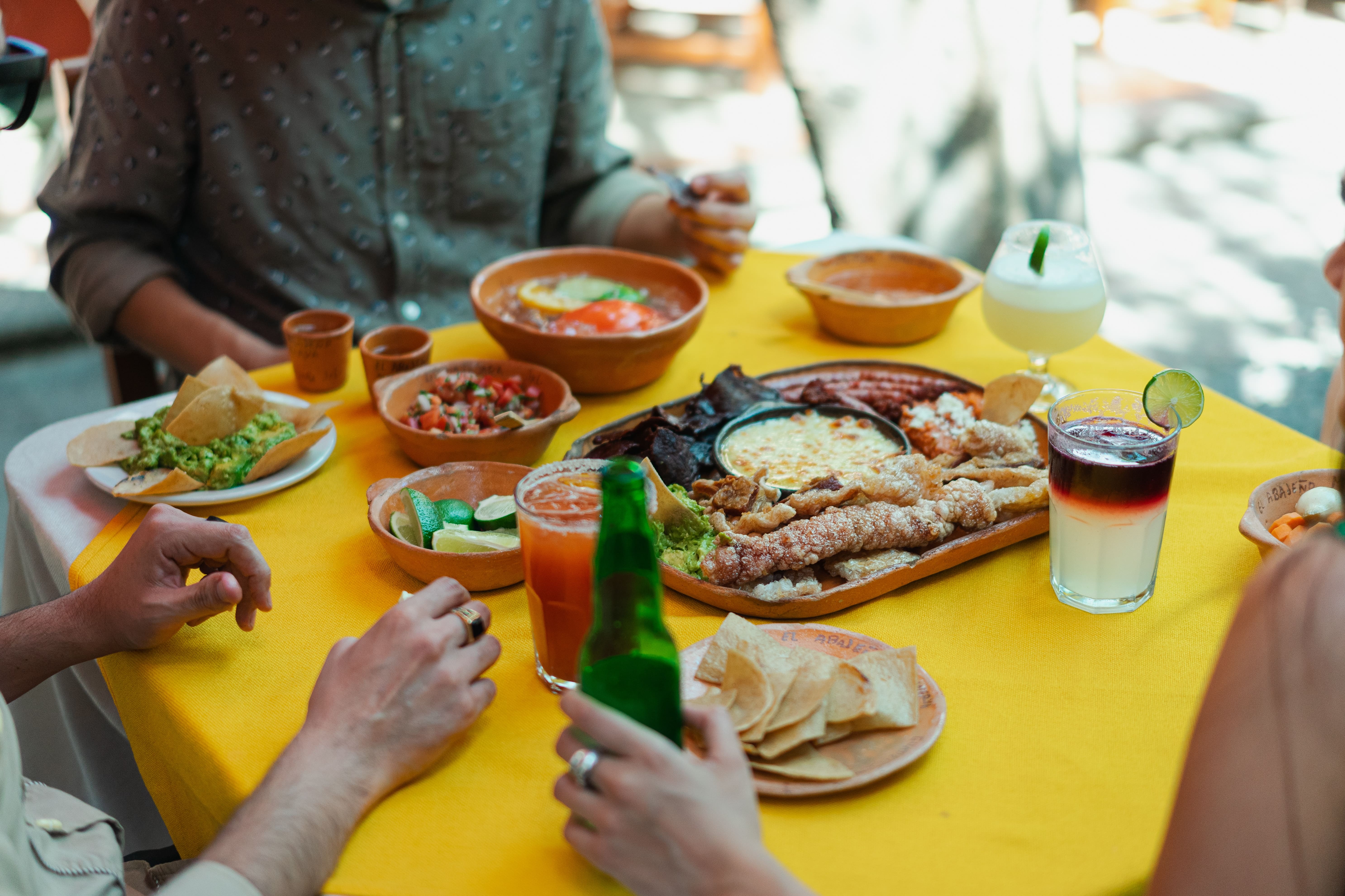 Pepople sitting at a table with food and drinks