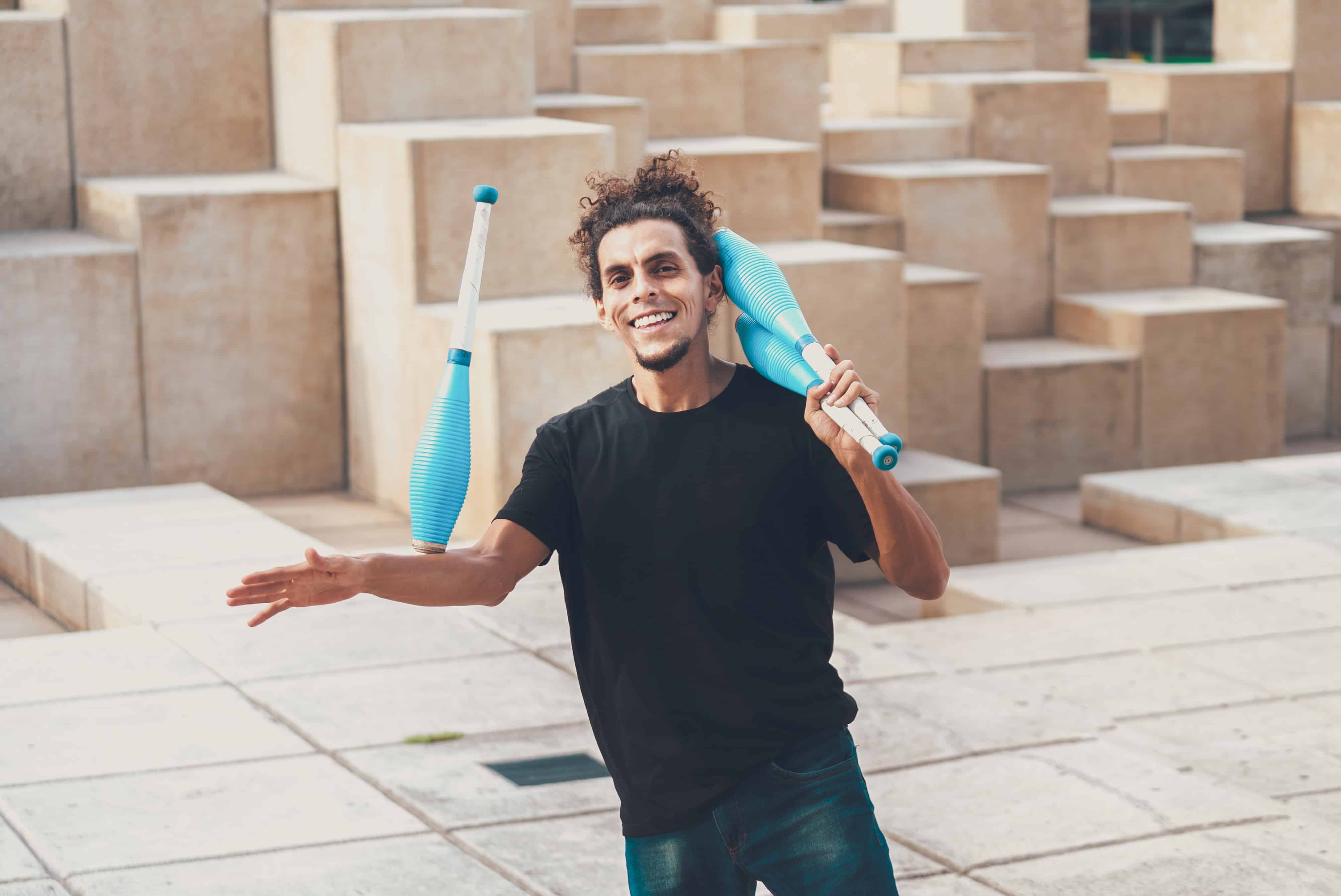 A man juggles in a plaza