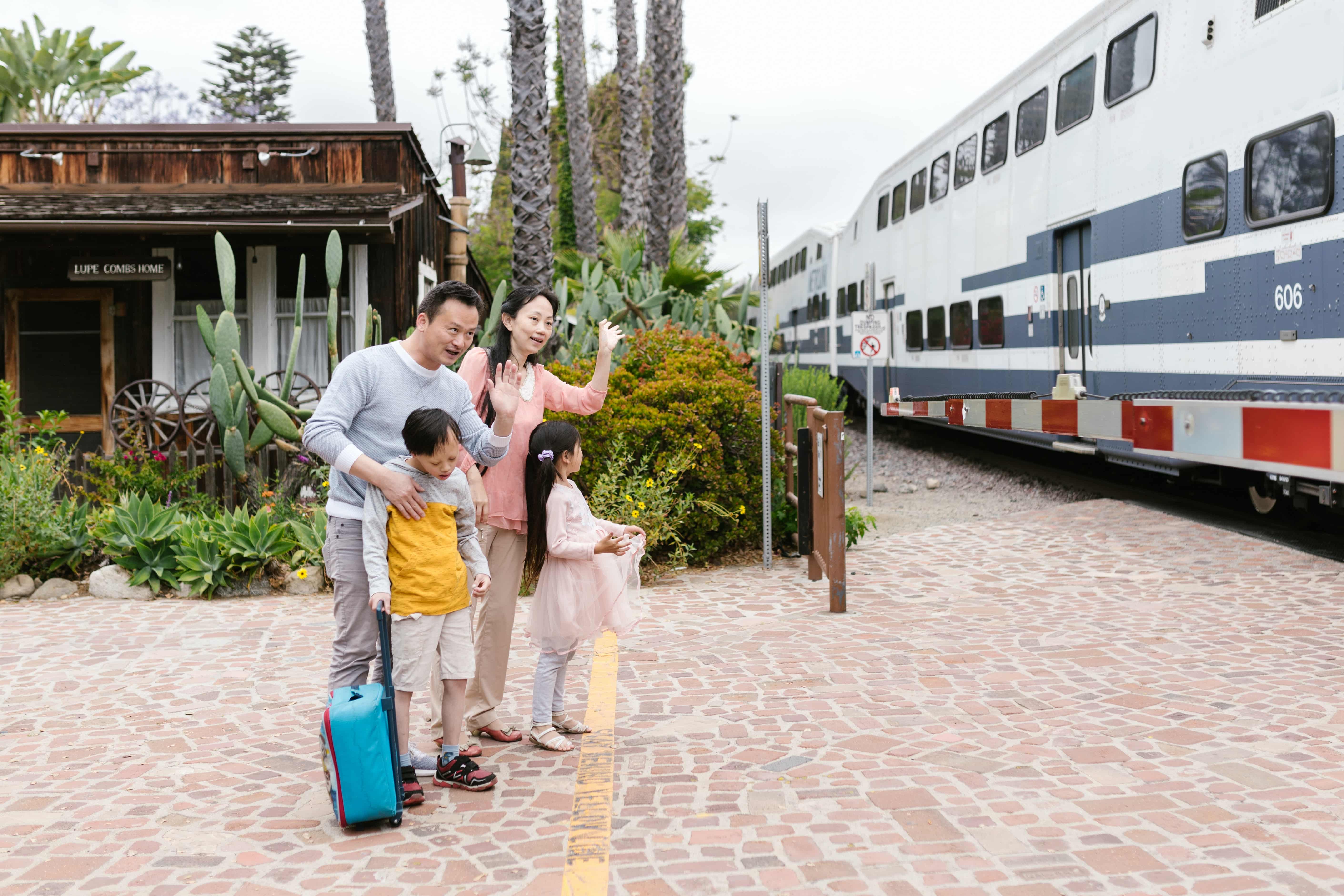 A family waves goodbye to someone on a train