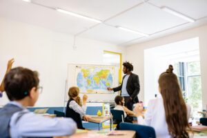 picture-of-a-teacher-pointing-at-a-map-in-front-of-students-in-a-classroom