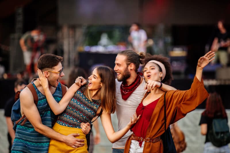 group-of-two-men-and-two-women-arm-in-arm-and-happy